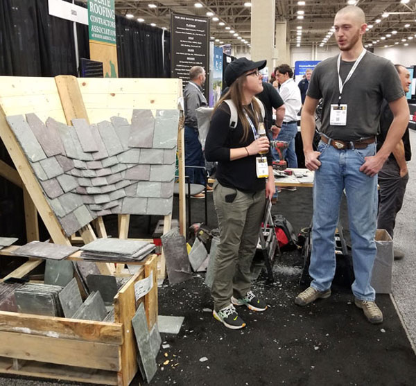 Dominic Nave of Jenkins Slate Masters Inc. demonstrates a woven slate valley at the SRCA booth at the 2023 IRE in Dallas, Texas
